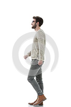 Side view.Young smiling man walking forward