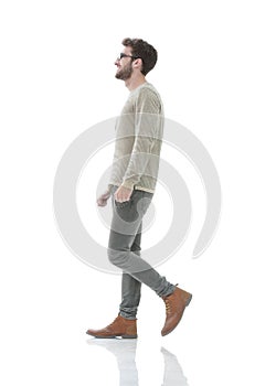 Side view.Young smiling man walking forward