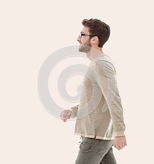 Side view.Young smiling man walking forward