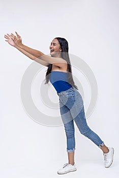 Side view of a young southeast asian woman tries to catch something falling. Reaching out with her arms. Full body photo isolated