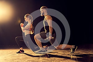 Side view of young sporty man and woman training