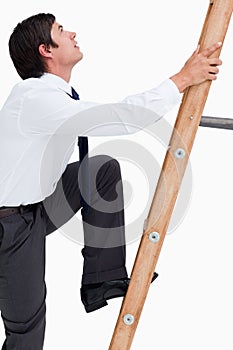 Side view of young tradesman climbing a ladder