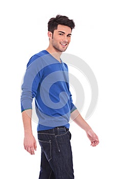 Side view of a young walking smiling man