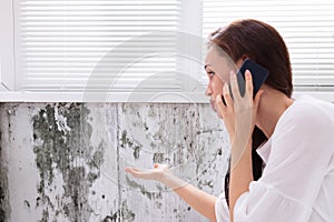 Woman Calling For Assistance Near Damaged Wall photo