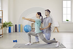 Side view of young woman doing forward lunges at physiotherapy rehabilitation clinic