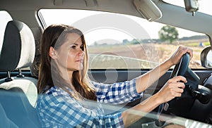 Side view of young woman driving car
