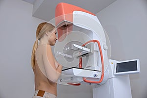 Side view of young woman getting mammogram test during breast cancer awareness program