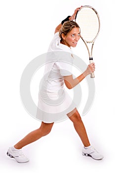 Side view of young woman playing tennis