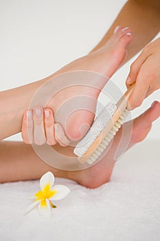 Side view of a young woman receiving pedicure treatment