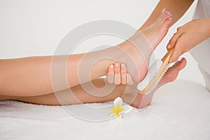 Side view of a young woman receiving pedicure treatment