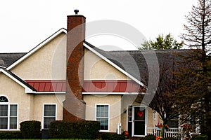 Side of white house with tall red brick chimney outdoor