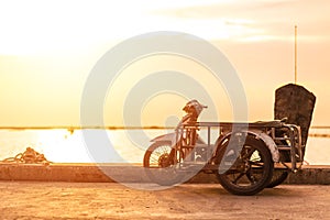 A sidecar motorcicle near the sea with sunset photo