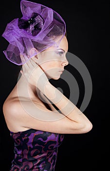 Sideview of beautiful young woman in violet hat