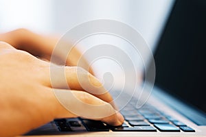 Sideview of businessman using laptop on desk