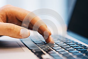 Sideview of businessman using laptop on workspace