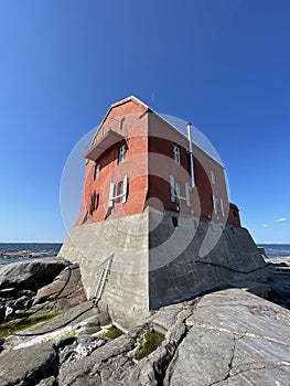 Sideview of crimson lighthouse with blue sky photo
