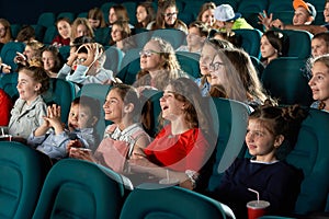 Sideview of laughing children in the cinema.