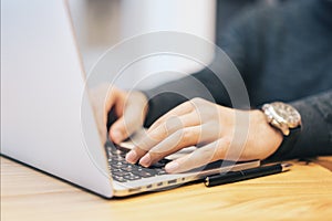 Sideview of man using laptop on desktop