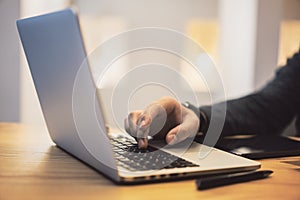 Sideview of man using notebook on desktop