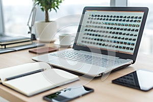 Sideview of office desktop with blank laptop and various tools.