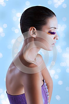 Sideview portrait of a fashion model with bird feather eyelashes abstract makeup