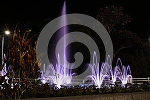 Sideview of a with purple light illuminated fountain in different sizes