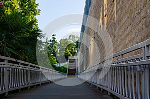 A sidewalk with a metal fence and a staircase