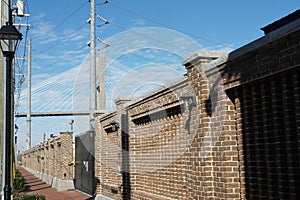 Sidewalk with old wall built of brown bricks in southern style with historical street lamps.