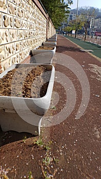 this is a sidewalk street on the side of the highway next to it there are flower pots that are neatly lined up