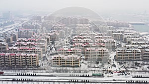 Sideward shot of residential buildings in Chinese city in heavy snow