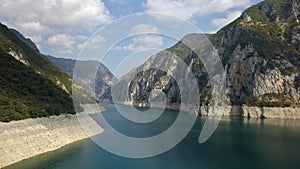 Sidewards reveal of the beautiful mountains surrounding Piva Lake near Pluzine, Montenegro. 4K shot in the Tara River