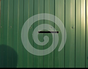 Siding, metal vertical panels texture closeup in the daytime outdoors. Metal wall or fence embossed metal sheets