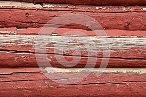 siding of an old red log barn with peeling paint