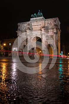 The Siegestor Victory Arch in Munich. Triumphal arch at night on a rainy day. Side view.