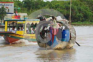 People ride traditional wooden boat at the Tonle Sap lake in Siem Reap, Cambodia.