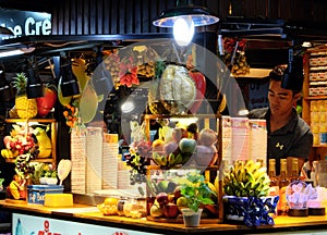 Fruit ice cream and cocktail kiosk, young Asian male seller, fruit shop