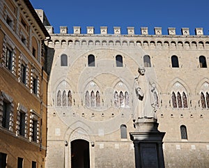 Siena, SI, Italy - February 20, 2023: Headquarters of the Italian bank called MONTE DEI PASCHI DI SIENA with statue
