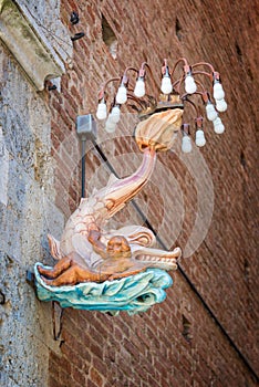 Siena in Tuscany, Italy - A dolphin, emblem of the Onda contrada wave district in a street during the palio festival