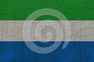 Sierra Leone flag on the background texture. Concept for designer solutions