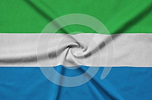 Sierra Leone flag is depicted on a sports cloth fabric with many folds. Sport team banner photo