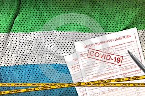 Sierra Leone flag and Health insurance claim form with covid-19 stamp. Coronavirus or 2019-nCov virus concept