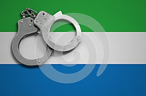 Sierra Leone flag and police handcuffs. The concept of crime and offenses in the country