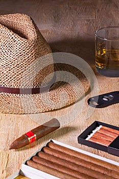 Siesta - cigars, straw hat and Scotch whiskey on a wooden desk