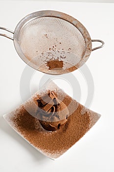 Sieving coco powder onto Chocolate muffin