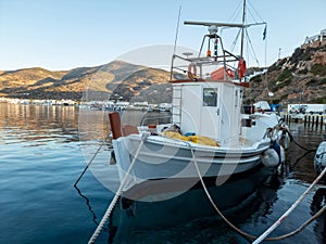 Sifnos island, Platis Gialos, Cyclades Greece. White fishing boat moored at dock