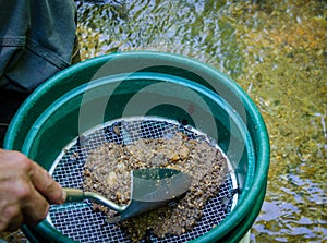 Sift and classify mineral rich soil with gold panning classifier pan.