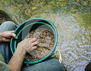 Sift and classify mineral rich soil with gold panning classifier pan.