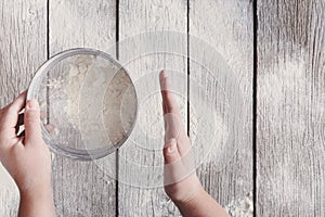 Sift flour top view on rustic wood background