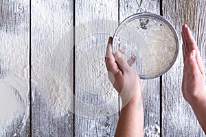 Sift flour top view on rustic wood background photo