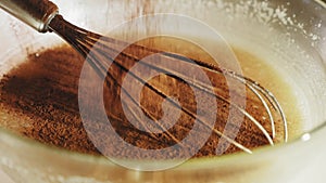 Sifting cocoa powder in a bowl with dough